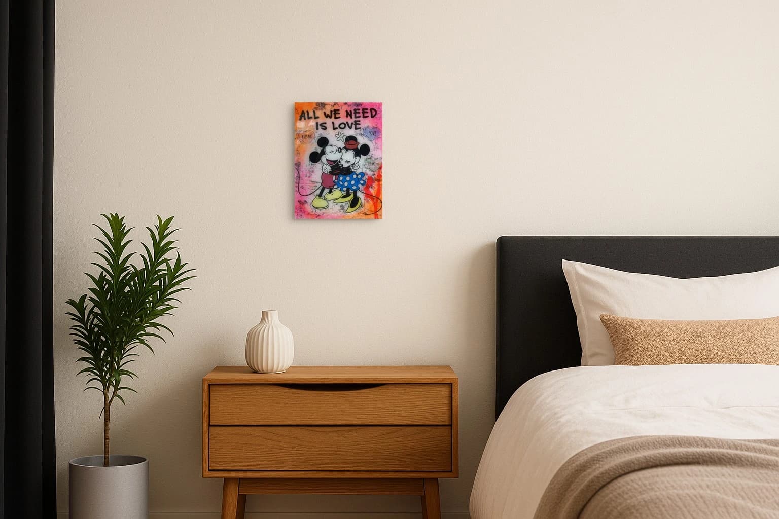 Mickey und Minnie umarmen sich vor ALL WE NEED IS LOVE mit Herzsymbolen auf pinkem Hintergrund, als Kunstwerk an der Wand eines Schlafzimmers.