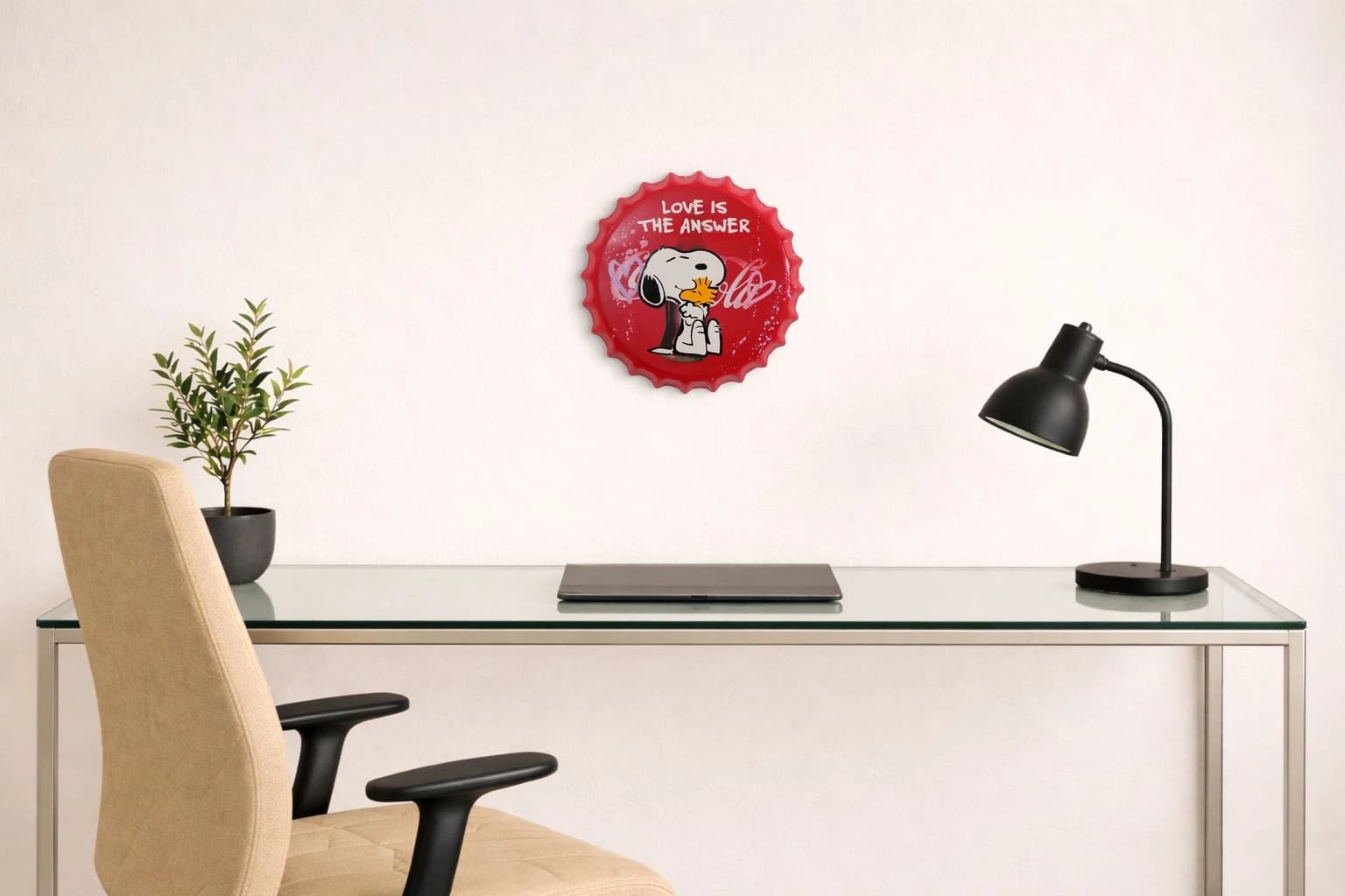 Roter Flaschendeckel mit Snoopy und dem Schriftzug „Love is the answer“ auf schwarzem Hintergrund, als Kunstwerk an der Wand eines Büros.