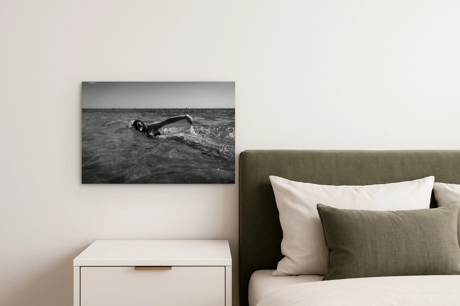 Eine Person schwimmt im Meer vor ruhiger Wasseroberfläche und Horizont, als Kunstwerk an der Wand eines Schlafzimmers.