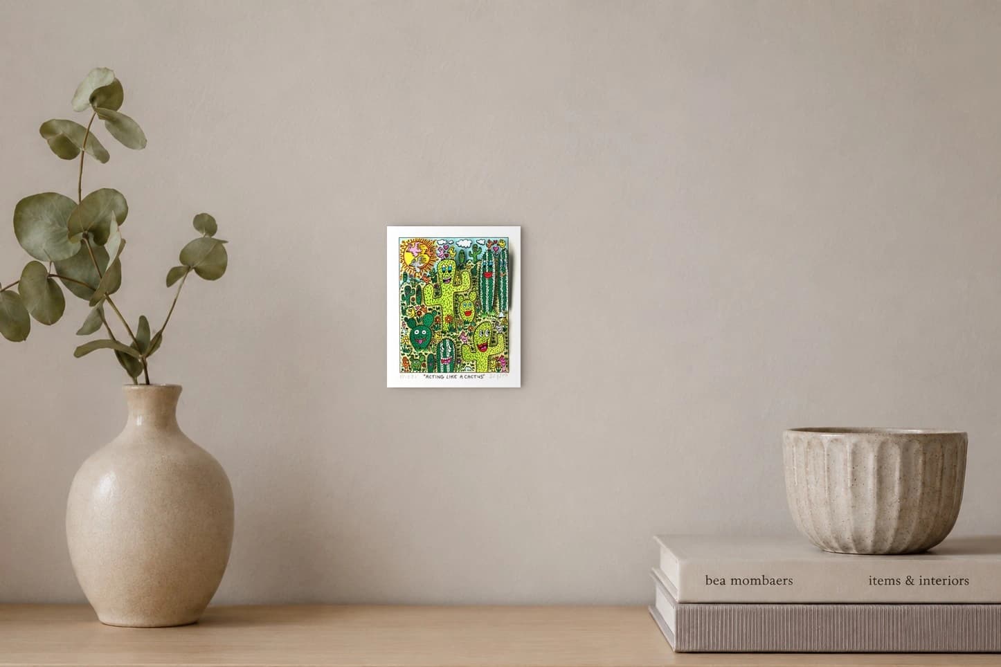 Bunte Cartoon-Kakteen mit Gesichtern, Vögeln und Blumen unter Sonne und Wolken, als Kunstwerk an der Wand eines hellen Raums.