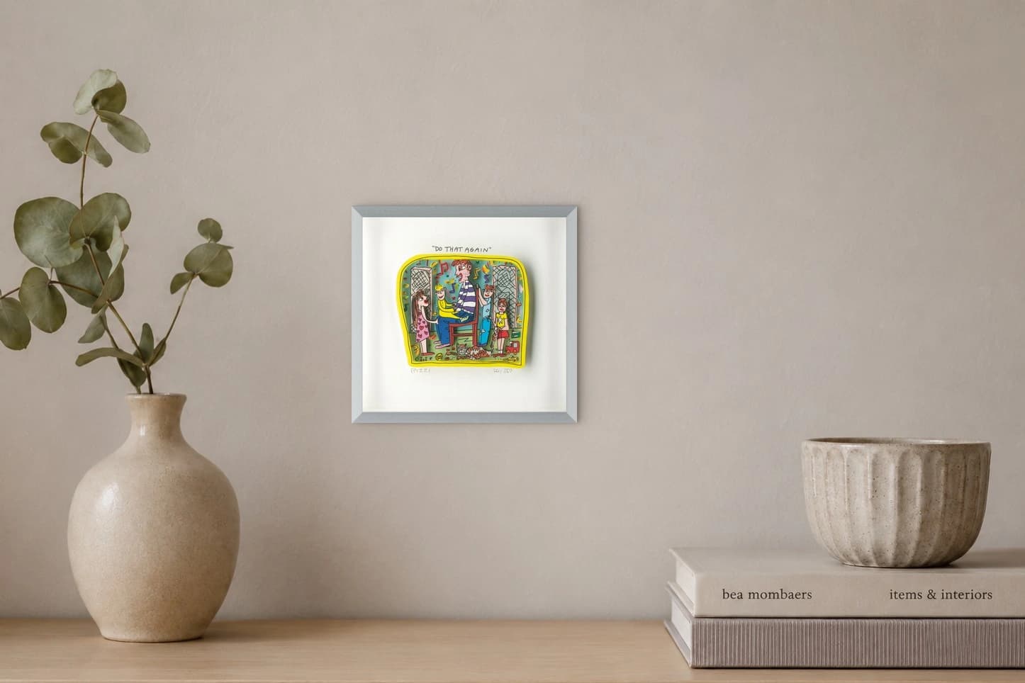 Gerahmtes Bild mit fünf Personen, Katzen, Musiknoten und gelbem Rand, als Kunstwerk an der Wand eines hellen Raums.