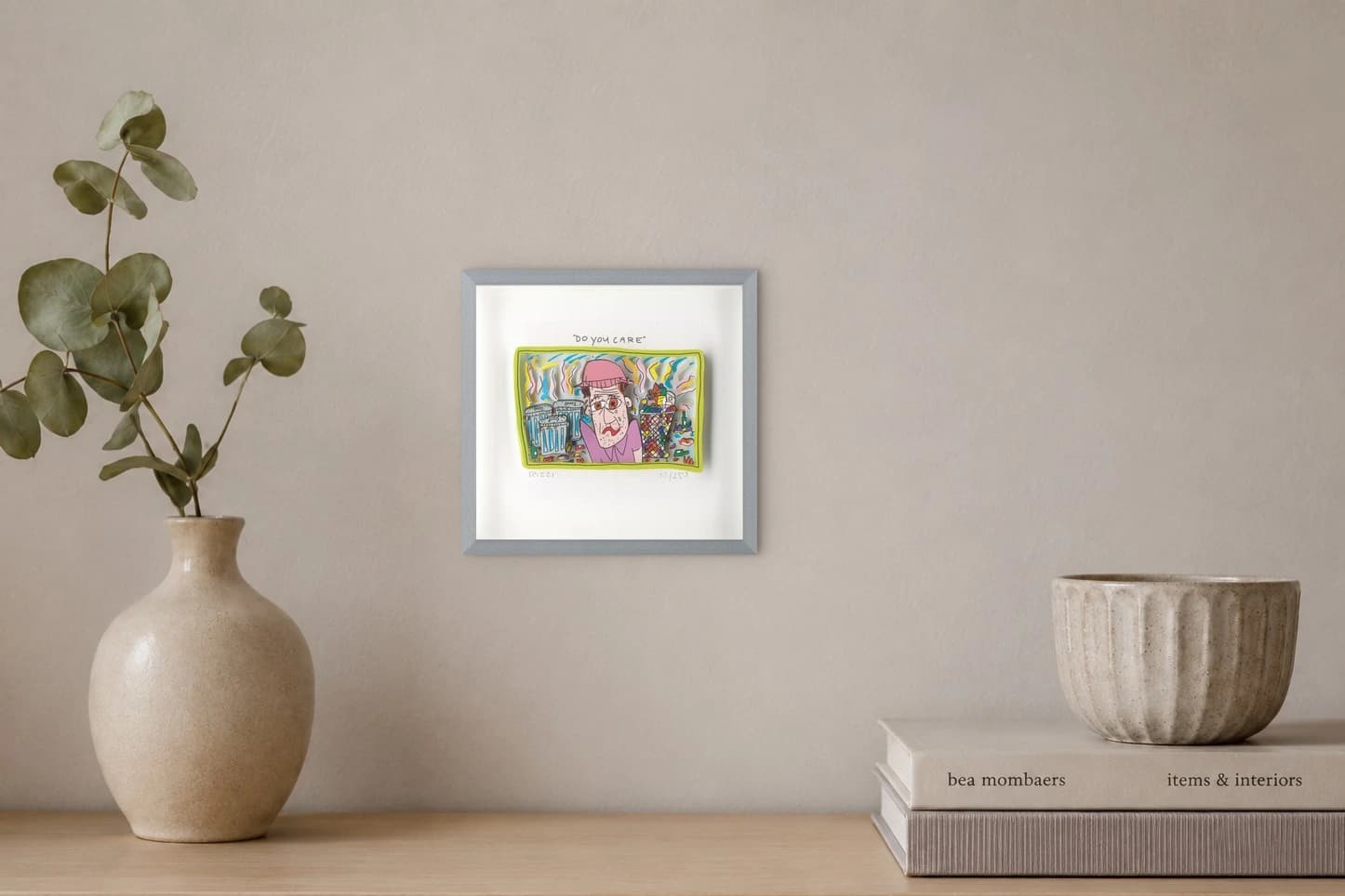 Gerahmte Zeichnung mit pinkhütiger Person, Mülltonnen, Müllkorb und „DO YOU CARE“, als Kunstwerk an der Wand eines hellen Raums.