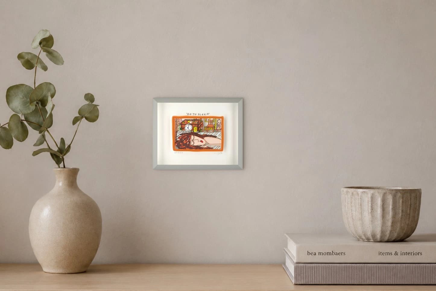 Gerahmtes Bild mit schlafender Frau, Uhr, Stuhl, Katze und Lampen, als Kunstwerk an der Wand eines hellen Zimmers.