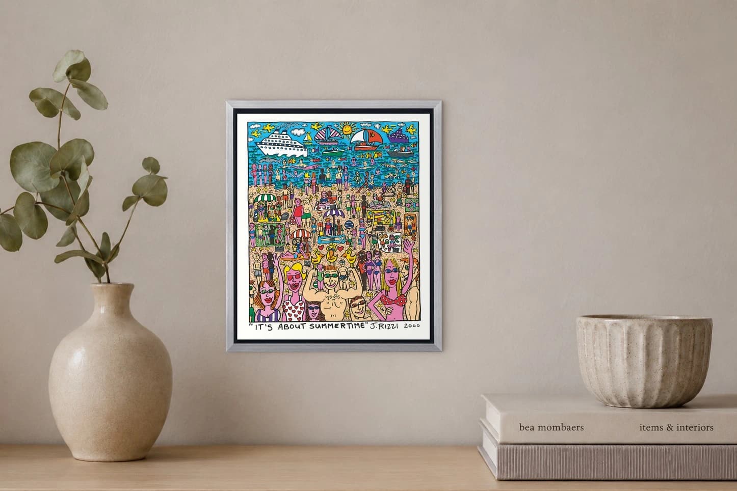 Gerahmtes Strandbild mit vielen Badenden, Booten, Sonnenschirmen und Schriftzug „It’s About Summertime“, als Kunstwerk an der Wand eines hellen Raums.