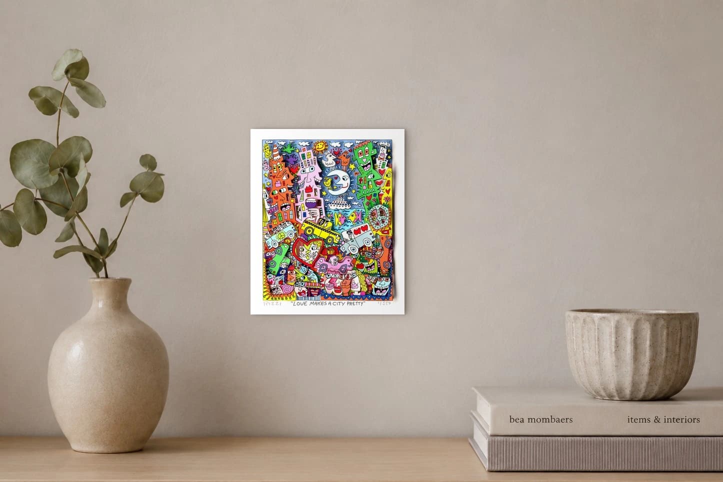 Bunte Gesichter-Häuser, Mond, Sonne, Autos, Taxi, Schiff und Fische vor blauem Himmel und Meer, als Kunstwerk an der Wand eines hellen Raums.