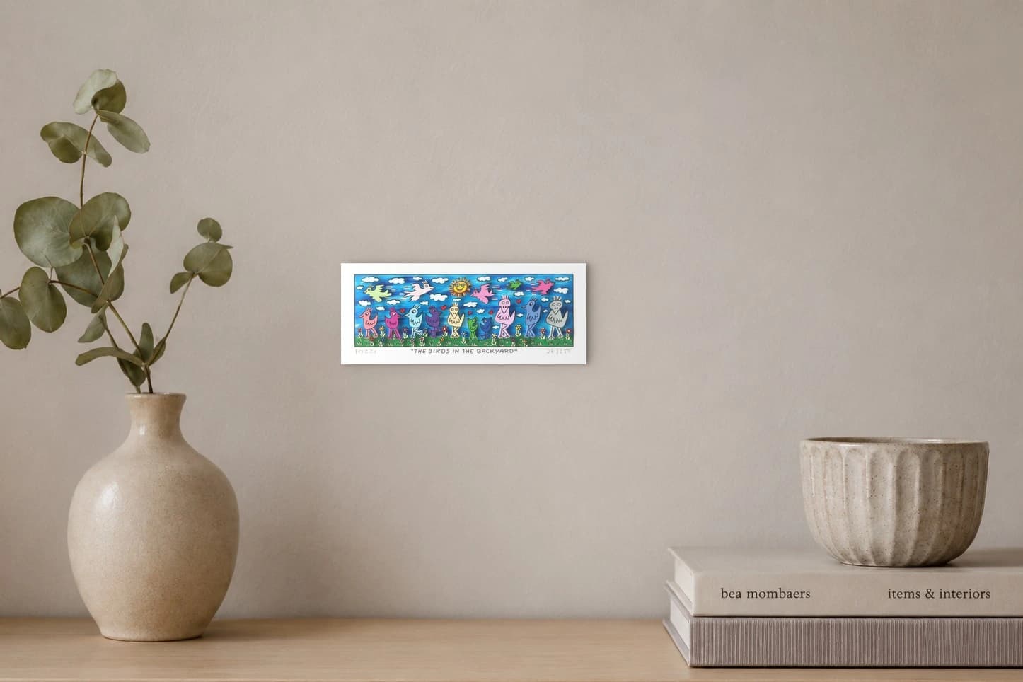 Bunte Vogel ﬁguren auf einer Blumenwiese vor blauem Himmel, als Kunstwerk an der Wand eines hellen Raums.
