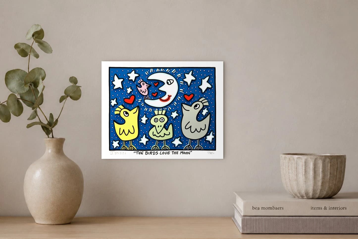 Vier bunte Vögel und eine weiße Mondsichel mit Herzen vor blauem Sternenhimmel im weißen Rahmen, als Kunstwerk an der Wand eines hellen Raums.