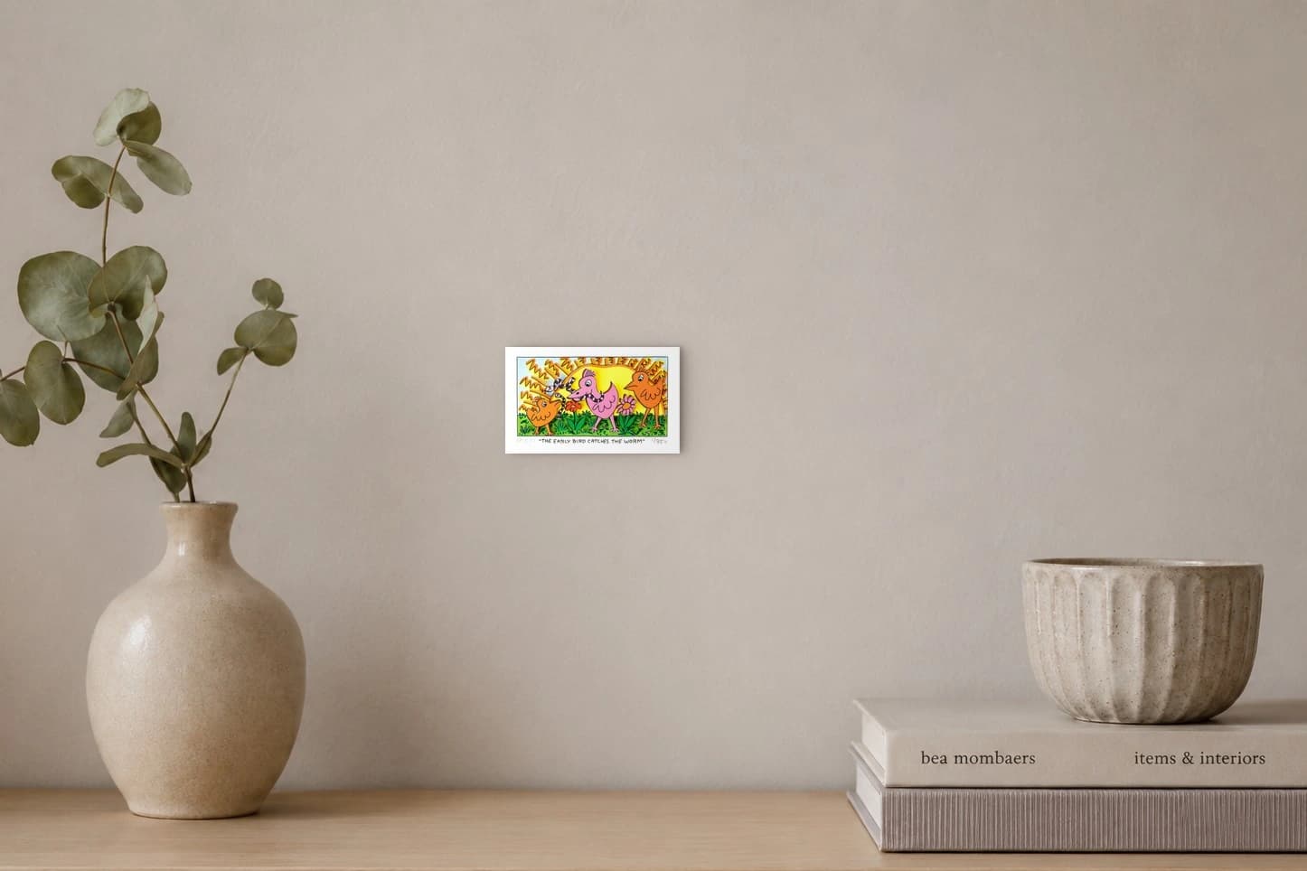 Drei bunte Vögel und zwei Würmer auf Gras vor gelbem Himmel mit orangefarbenen Linien, als Kunstwerk an der Wand eines hellen Raums.
