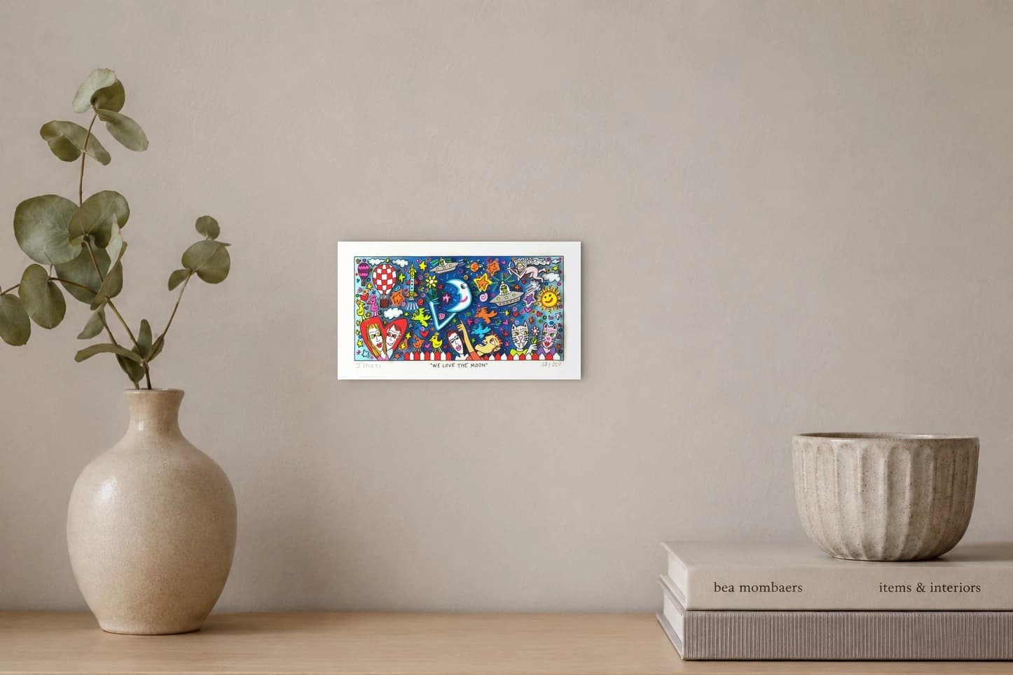Bunte Comic-Zeichnung mit Mond, Sonne, Sternen, Figuren und Flugobjekten auf blauem Hintergrund, als Kunstwerk an der Wand eines hellen Raums.