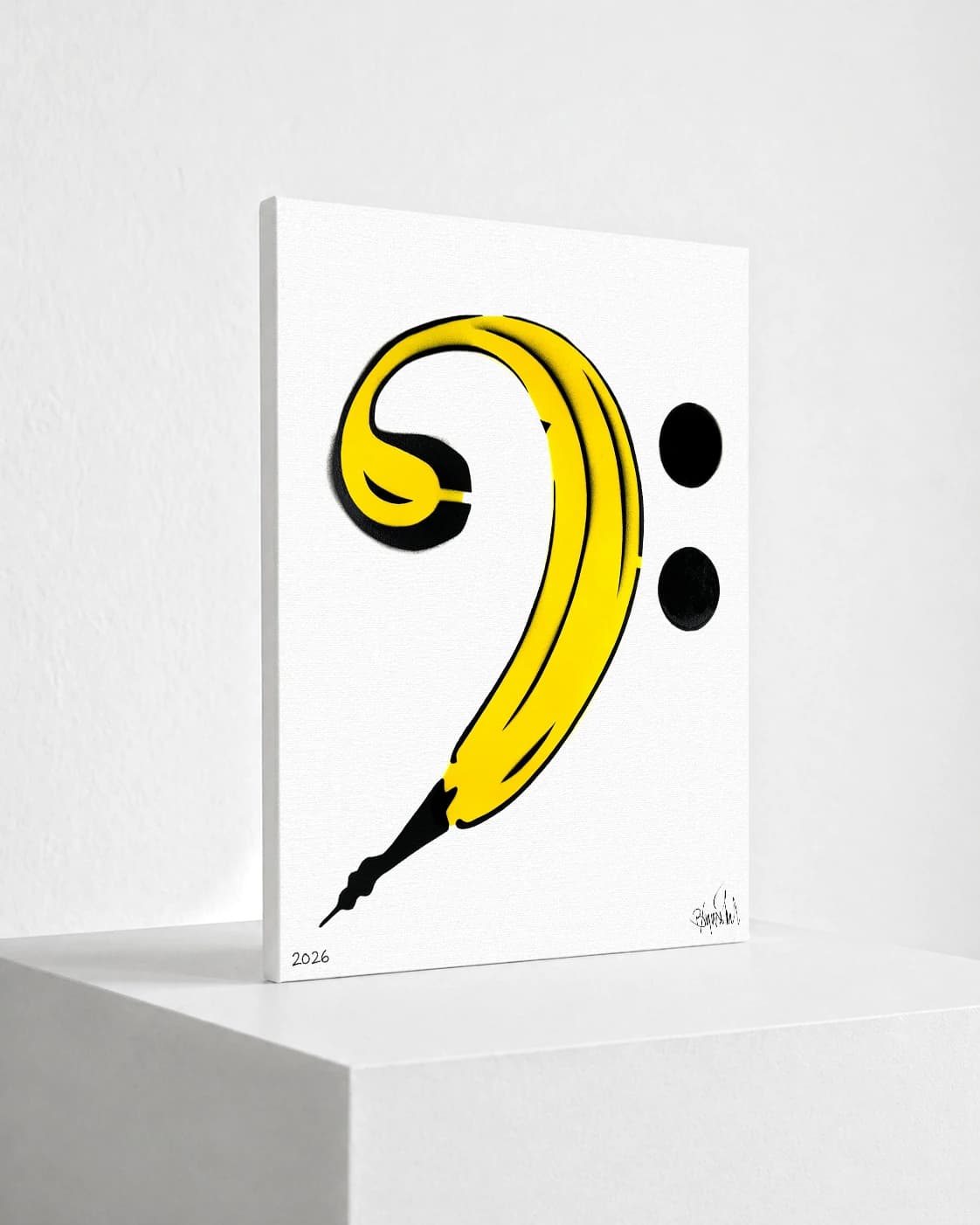 Gelbe Banane mit schwarzer Spitze, daneben zwei schwarze Punkte auf weißem Hintergrund, unten 2026.