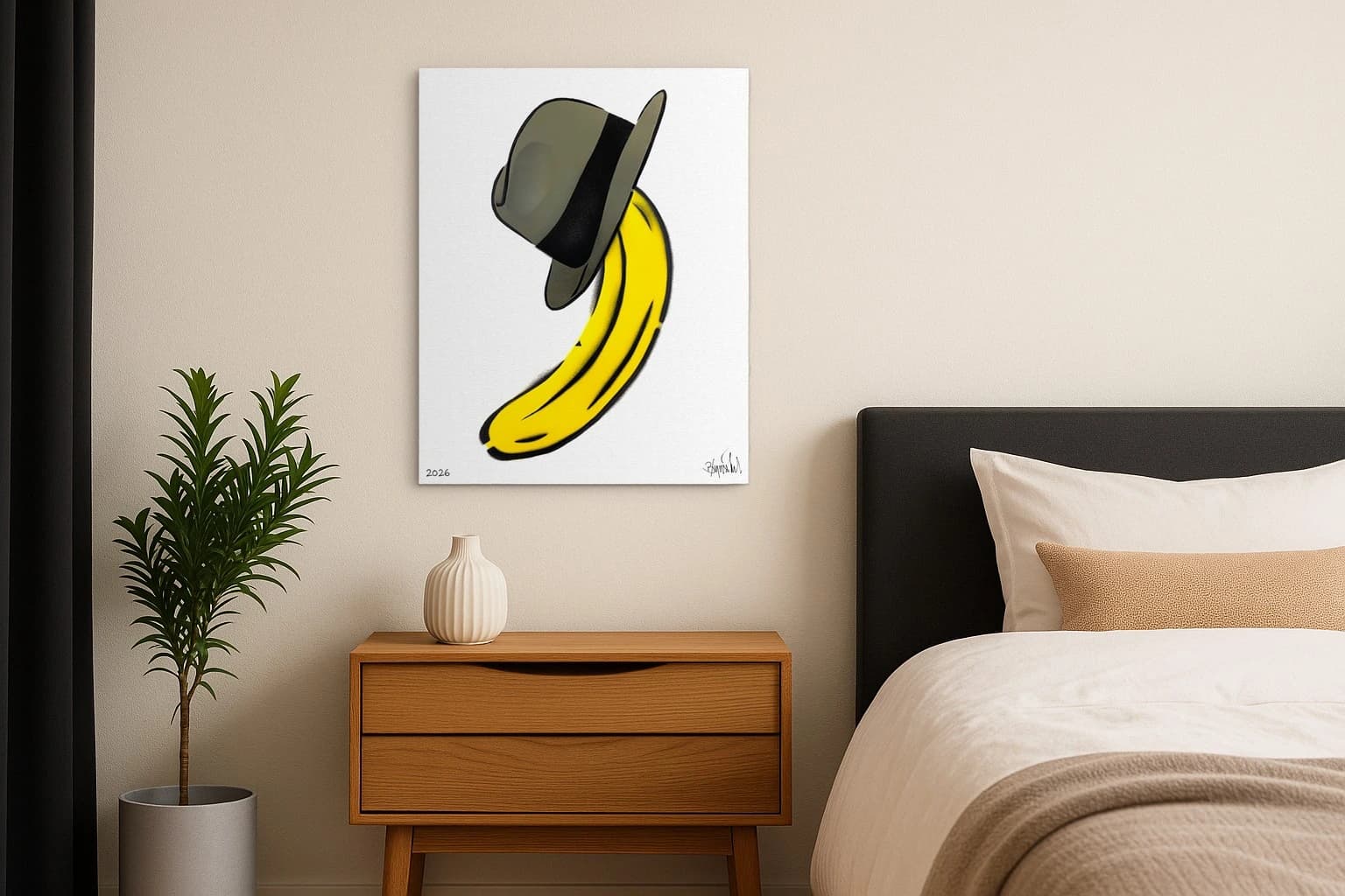 Gelbe Banane mit grauem Hut auf weißem Grund, unten links 2026 und rechts Signatur, als Kunstwerk an der Wand eines Schlafzimmers.