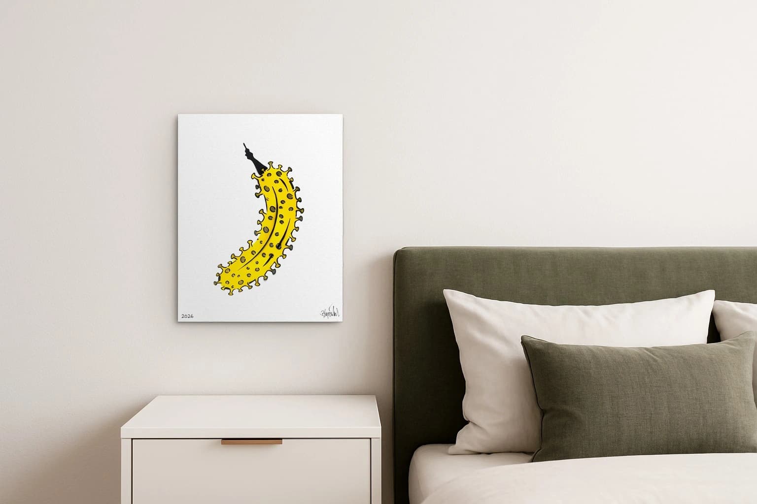 Gelbe Banane mit schwarzen Stacheln auf weißem Hintergrund, unten links 2026 und unten rechts Signatur, als Kunstwerk an der Wand eines hellen Schlafzimmers.