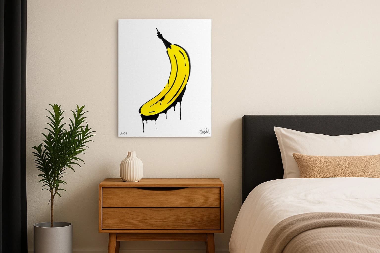 Gelbe Banane mit schwarzer Kontur und schwarzen Tropfen auf weißem Hintergrund, als Kunstwerk an der Wand eines Schlafzimmers.