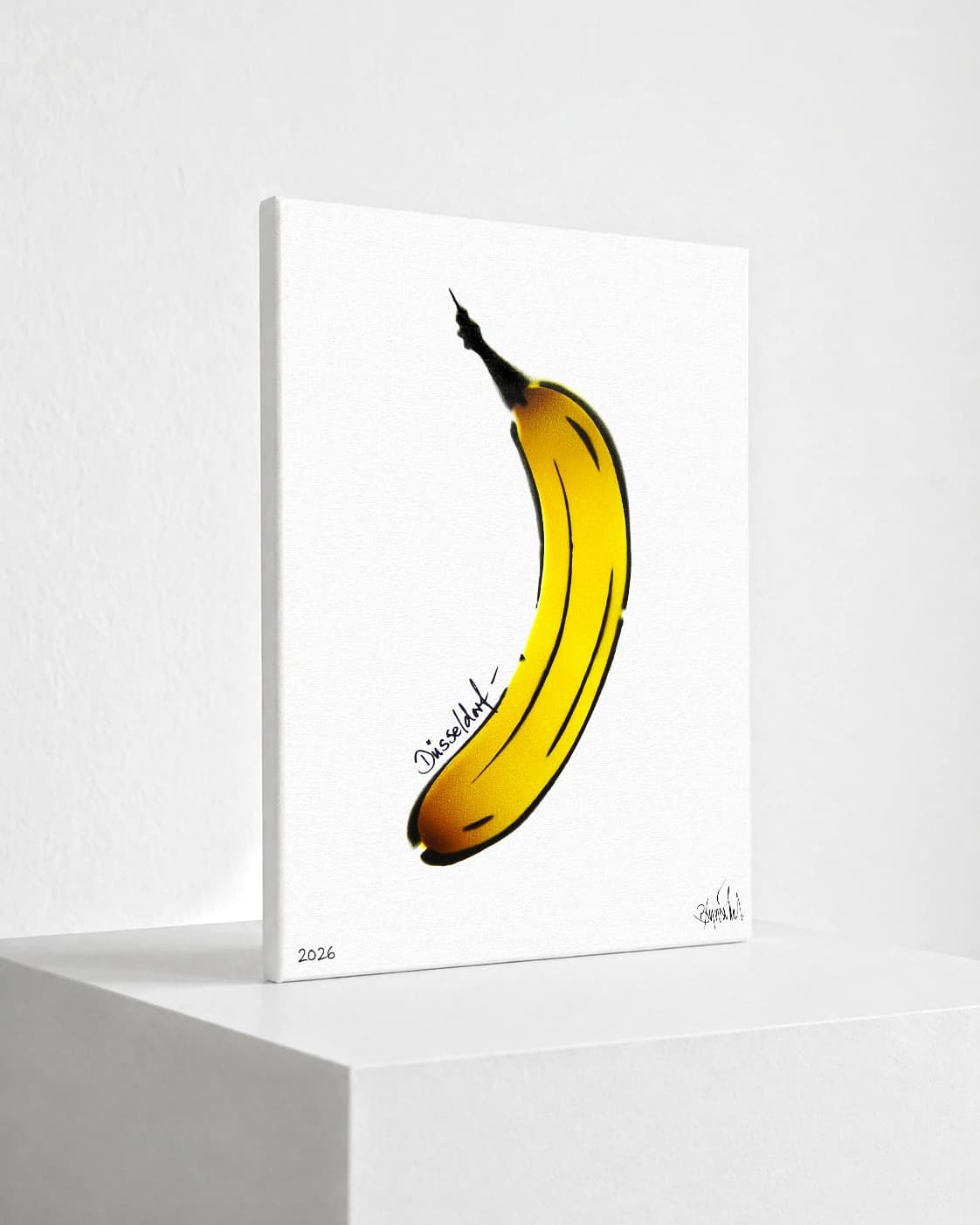 Gelbe Banane mit schwarzer Kontur auf weißem Hintergrund, unten links 2026 und Signatur.