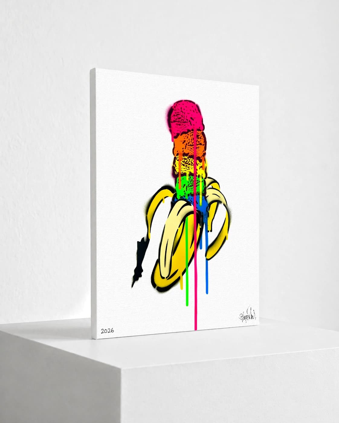 Bunte geschnittene Banane mit pinker Kugel, farbigen Tropfen und weißem Hintergrund.