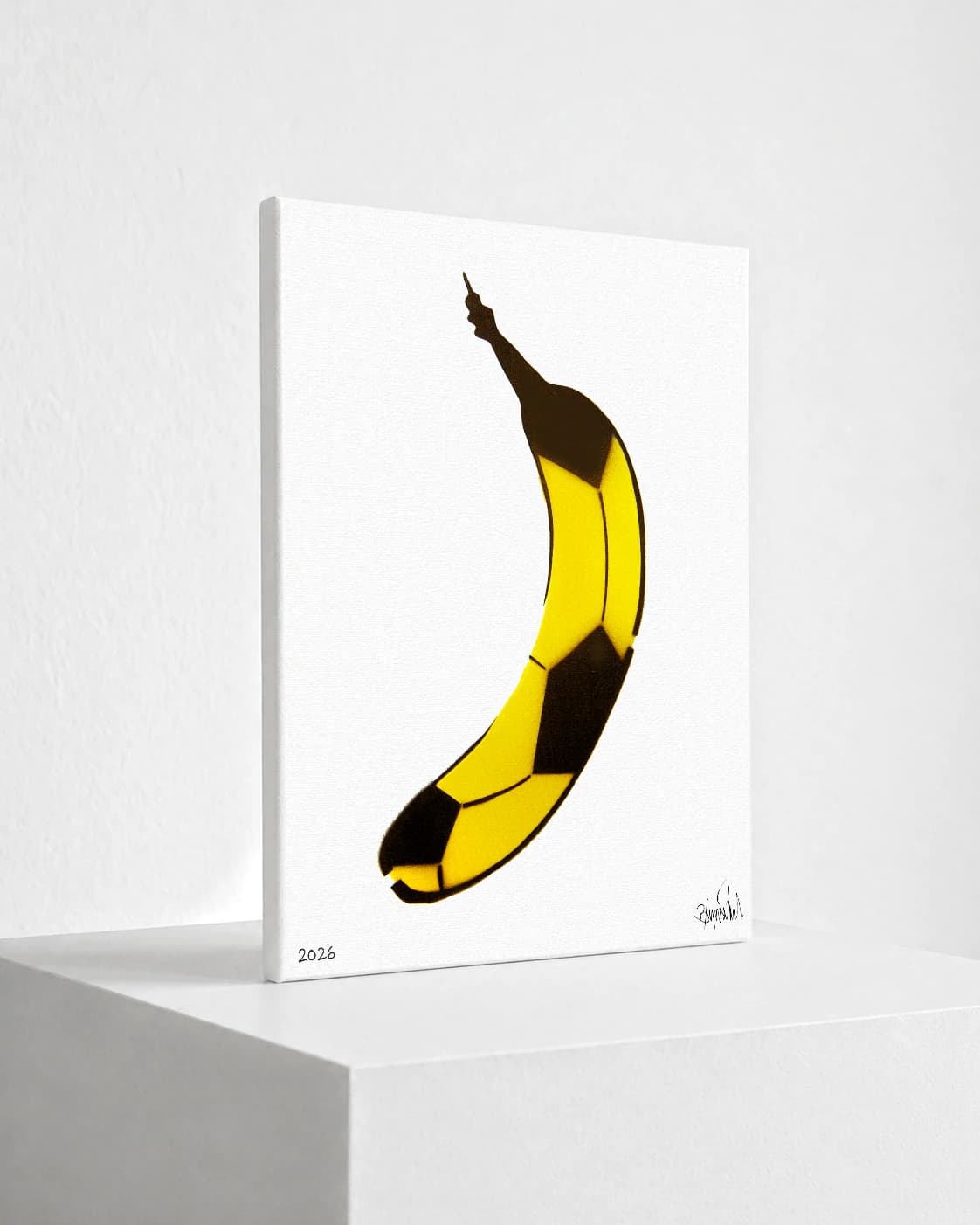 Gelbe Banane mit schwarzen Flächen auf weißem Hintergrund, unten links 2026 und unten rechts Signatur.