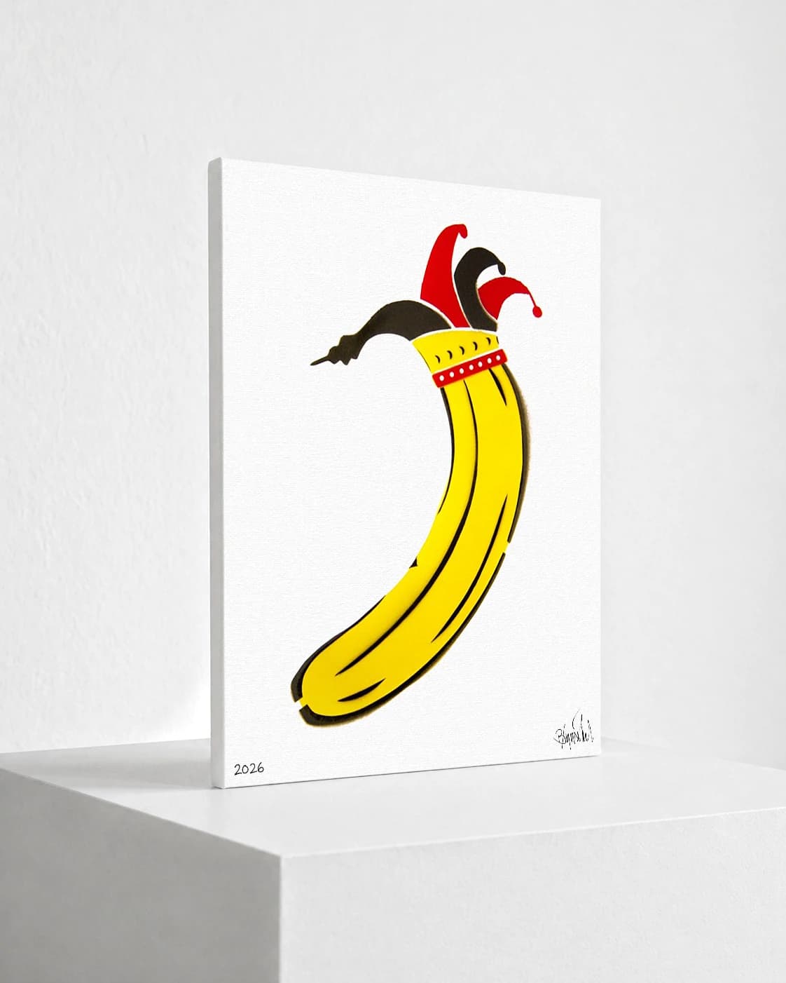 Gelbe Banane mit roter und schwarzer Narrenkappe auf weißem Papier, unten links 2026.