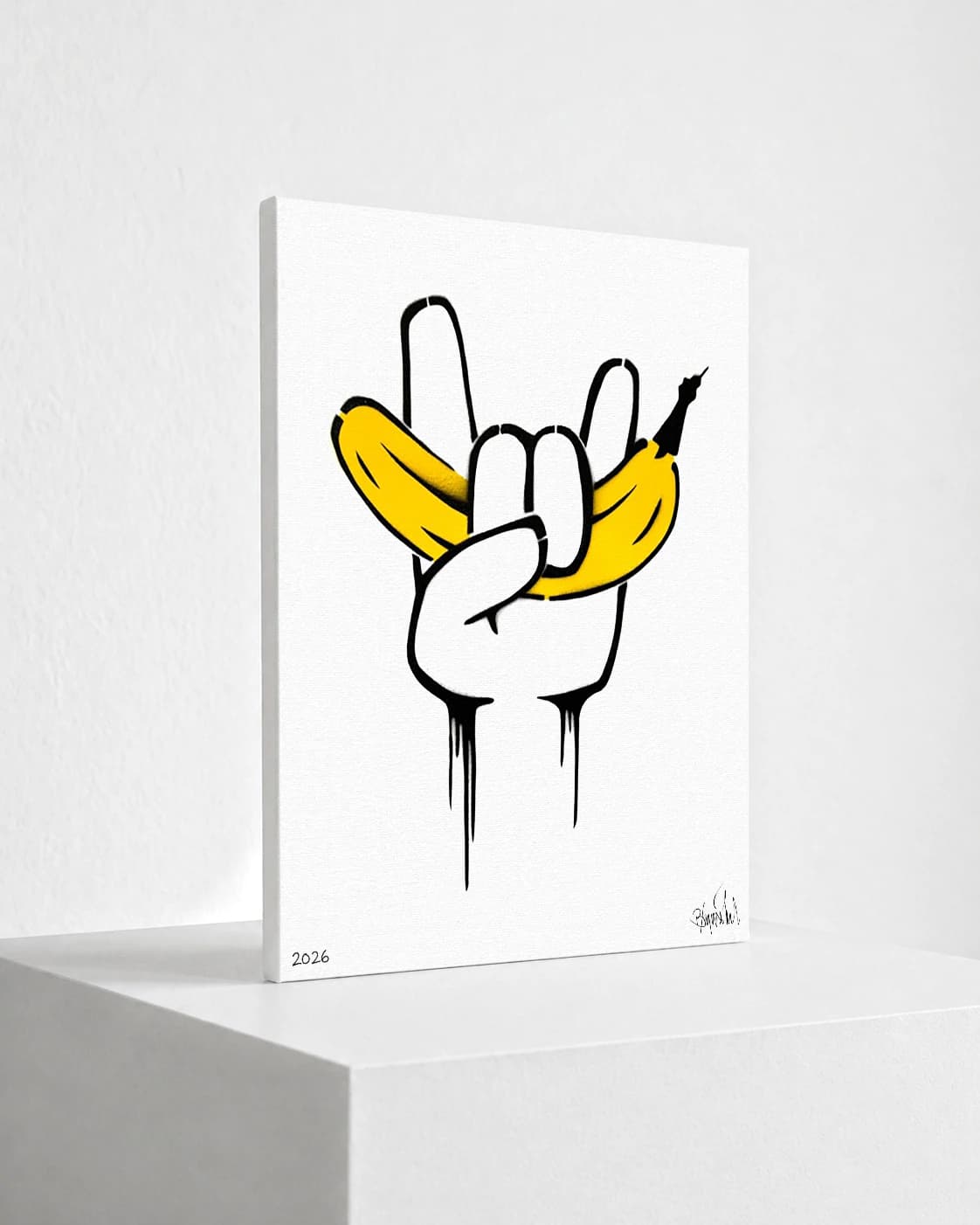 Weiße Hand macht das Victory-Zeichen mit gelber Banane zwischen den Fingern auf weißem Hintergrund.