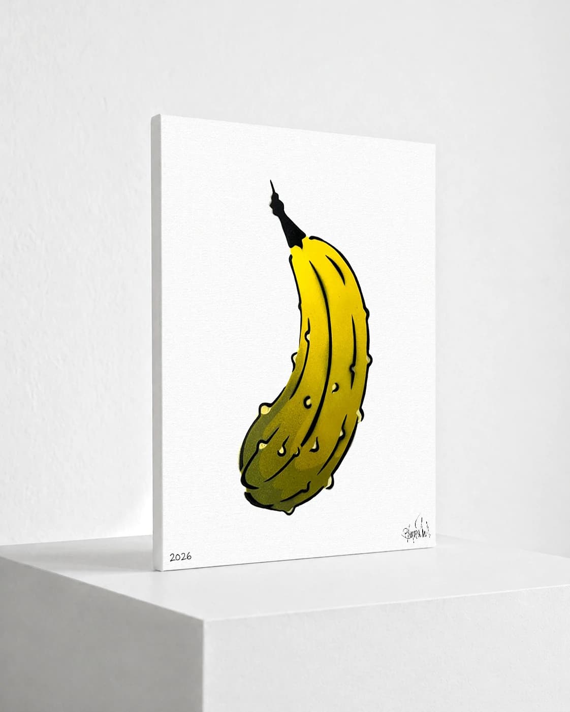 Gelbe Banane mit schwarzem Stiel auf weißem Papier, unten links 2026 und unten rechts Signatur.
