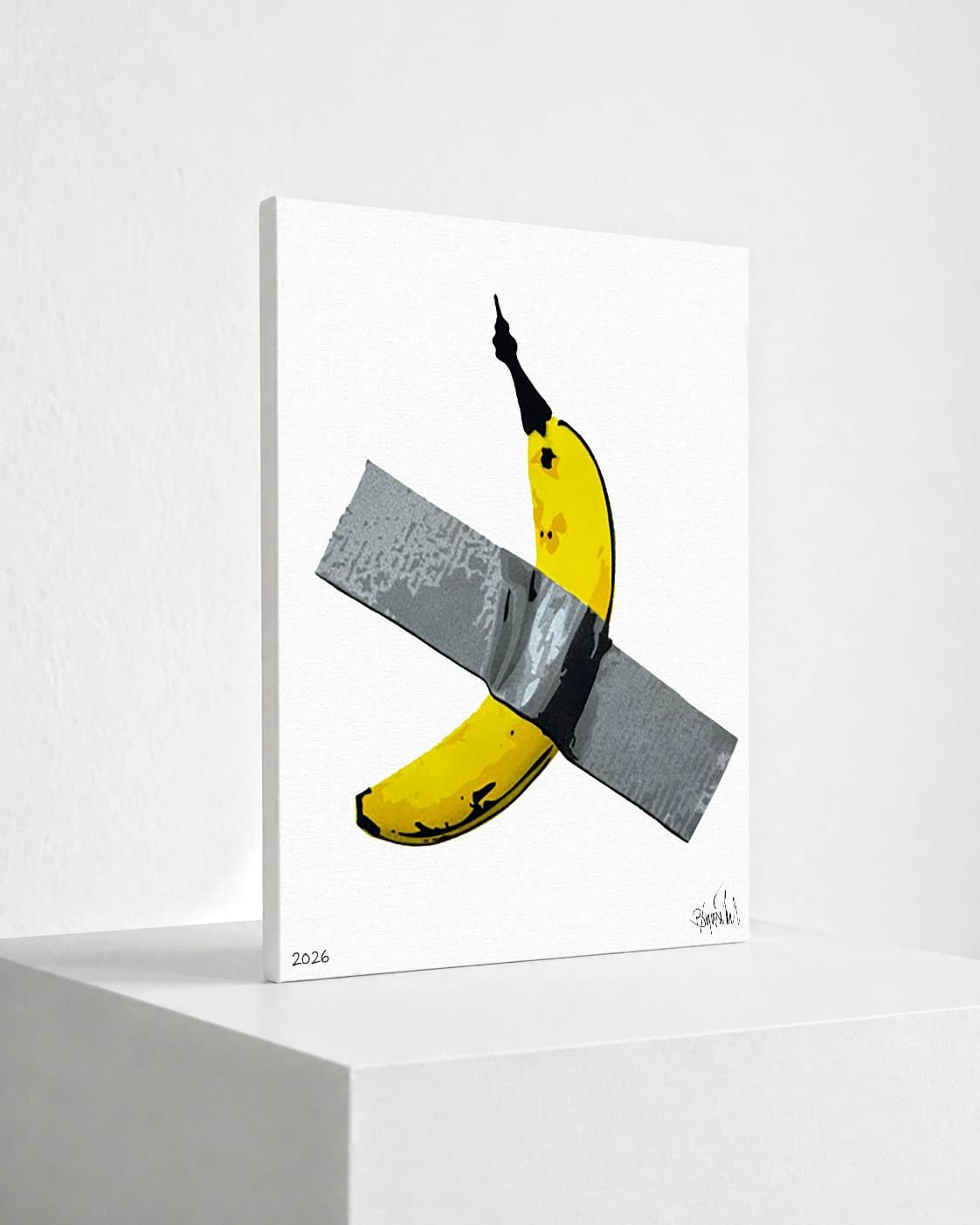 Gelbe Banane mit schwarzer Spitze unter einem grauen Klebestreifen auf weißem Grund, unten steht 2026.