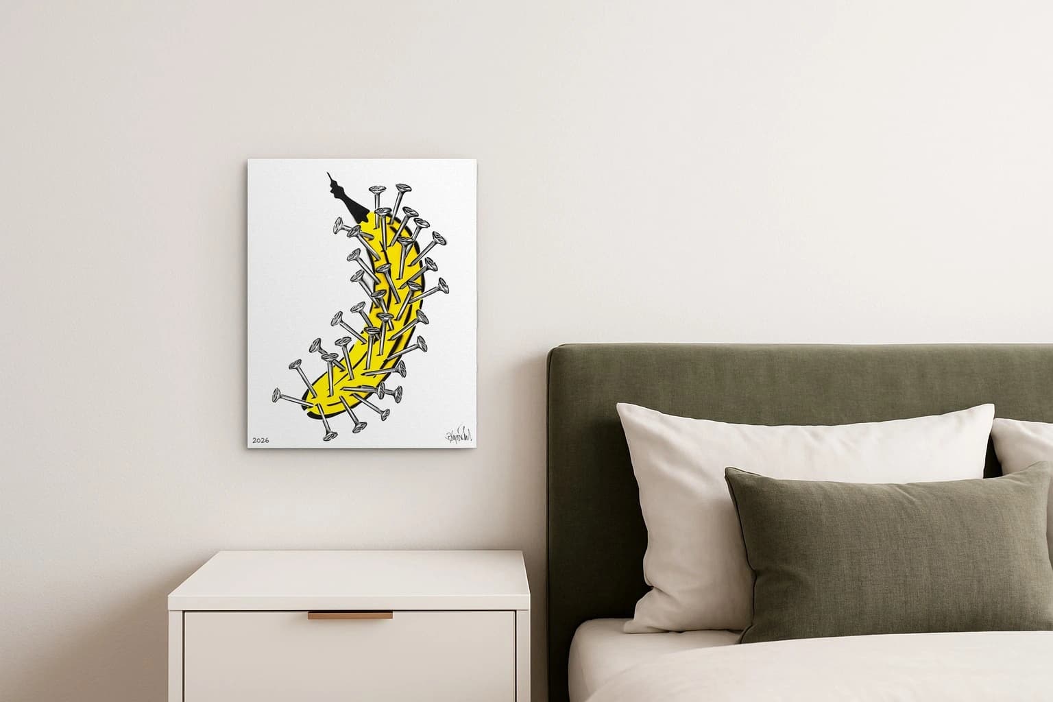 Gelbe Banane mit vielen Nägeln auf weißem Grund und 2026 unten links, als Kunstwerk an der Wand eines Schlafzimmers.