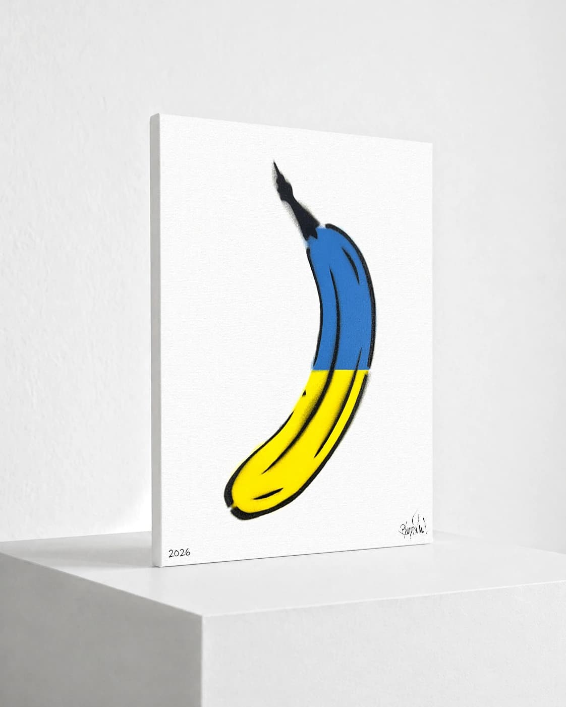 Gelbe Banane mit blauem oberen Teil auf weißem Hintergrund, unten links 2026.