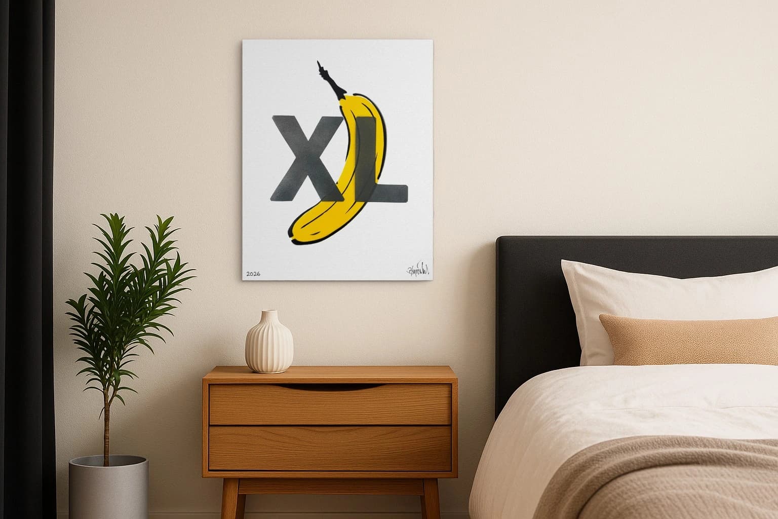 Eine diagonal liegende gelbe Banane hinter großen schwarzen Buchstaben XL auf weißem Grund, als Kunstwerk an der Wand eines Schlafzimmers.