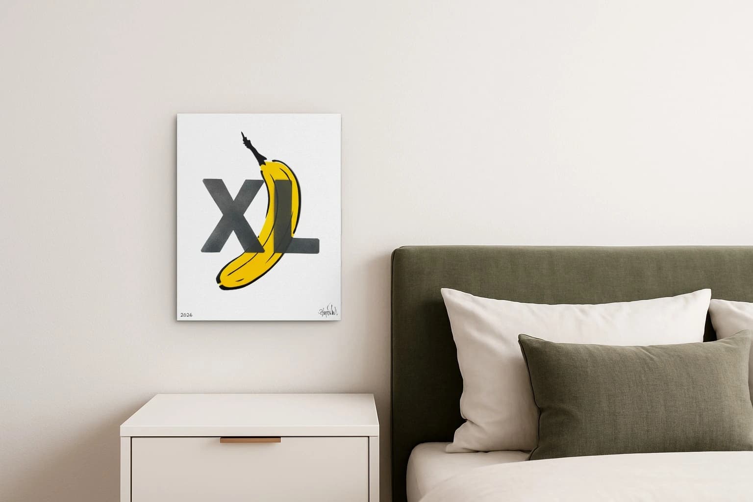 Eine gelbe Banane liegt diagonal hinter den schwarzen Buchstaben XL auf weißem Grund, als Kunstwerk an der Wand eines Schlafzimmers.