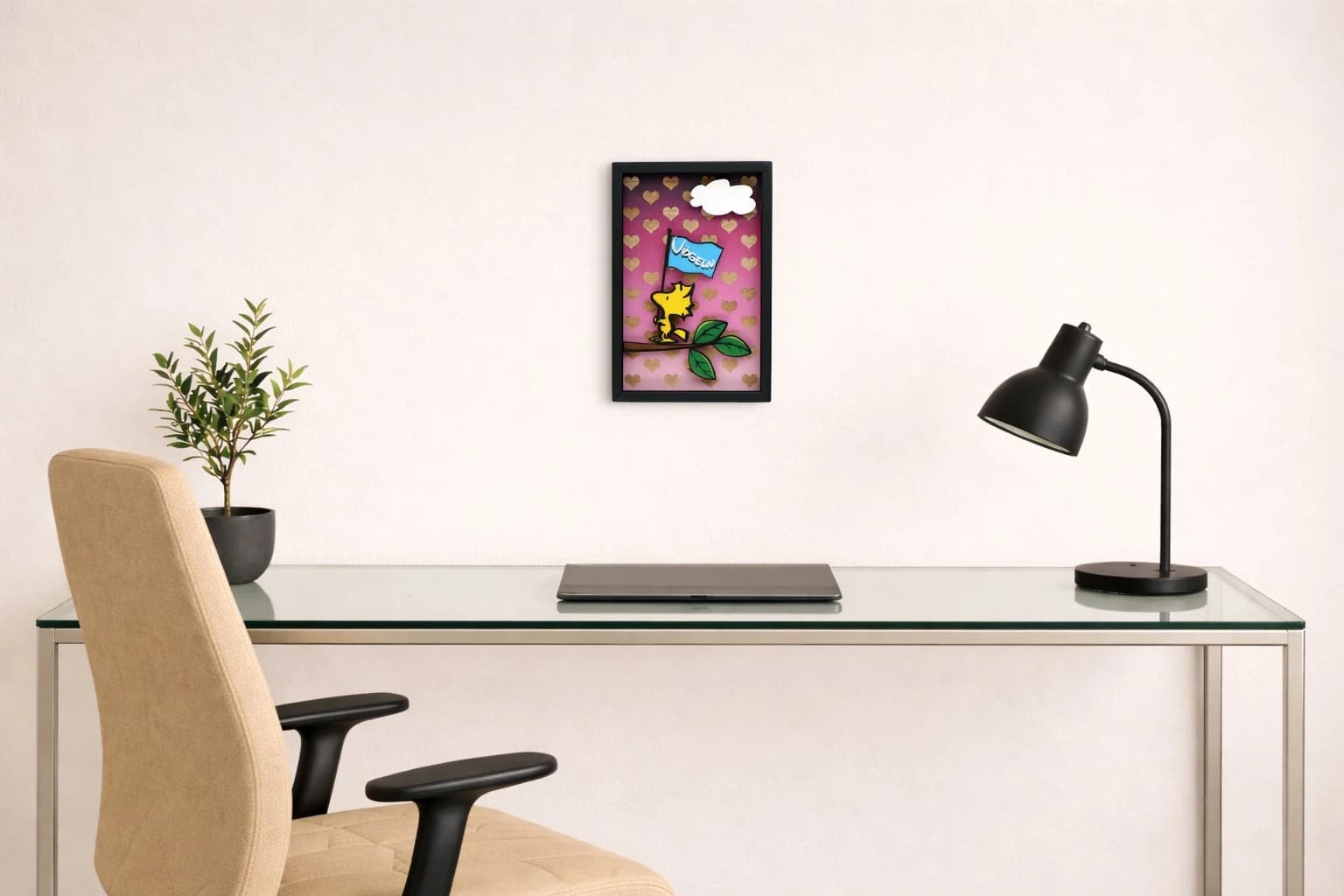 Woodstock auf einem Ast hält eine blaue Flagge vor rosa Hintergrund mit goldenen Herzen und weißer Wolke, als Kunstwerk an der Wand eines hellen Büros.