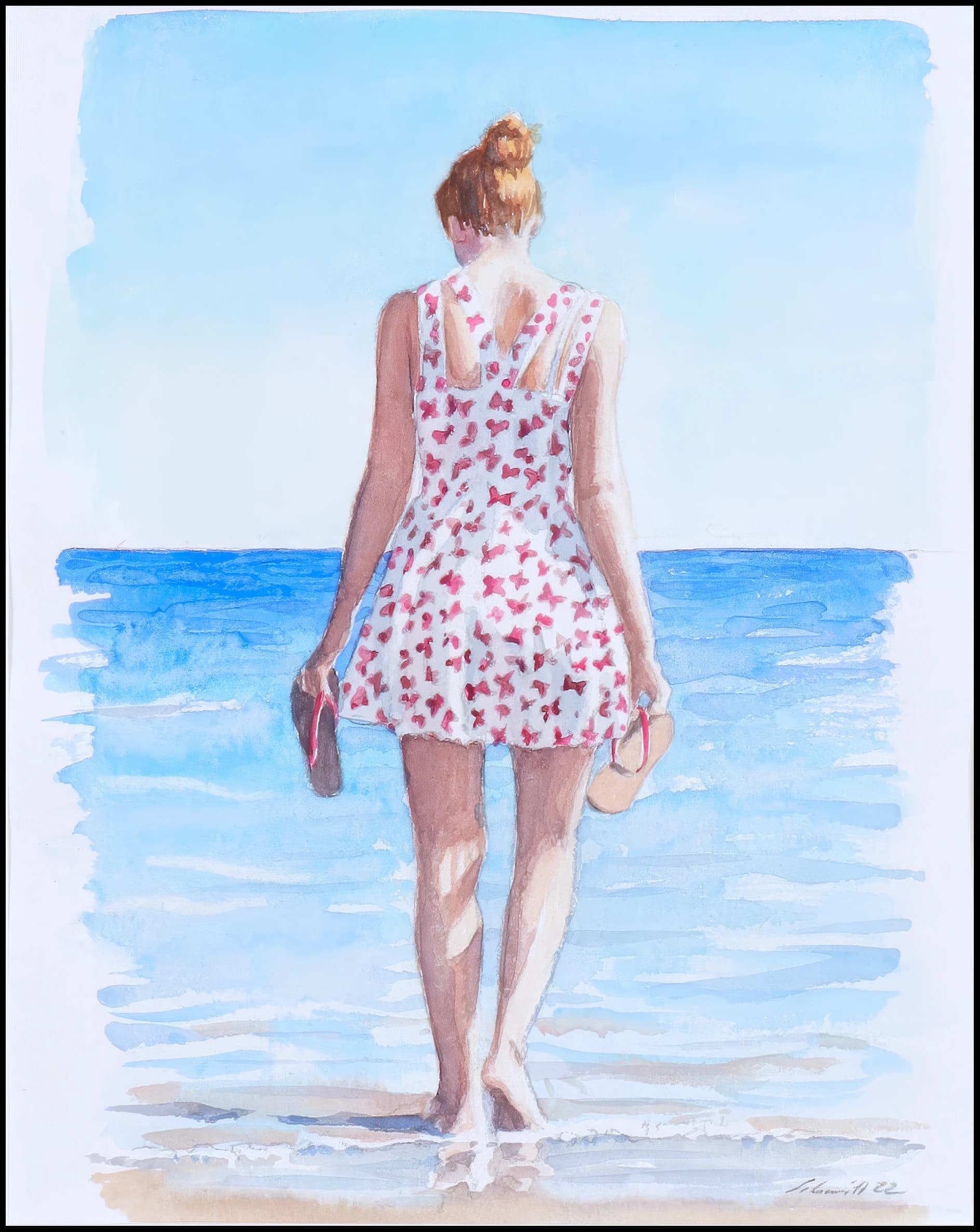 Eine Frau im geblümten Kleid geht barfuß zum Meer und hält Schuhe in den Händen.